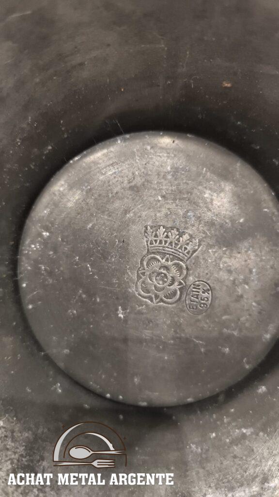 Poinçon étain 95 pour cent avec symbole couronné et fleur sur objet en étain